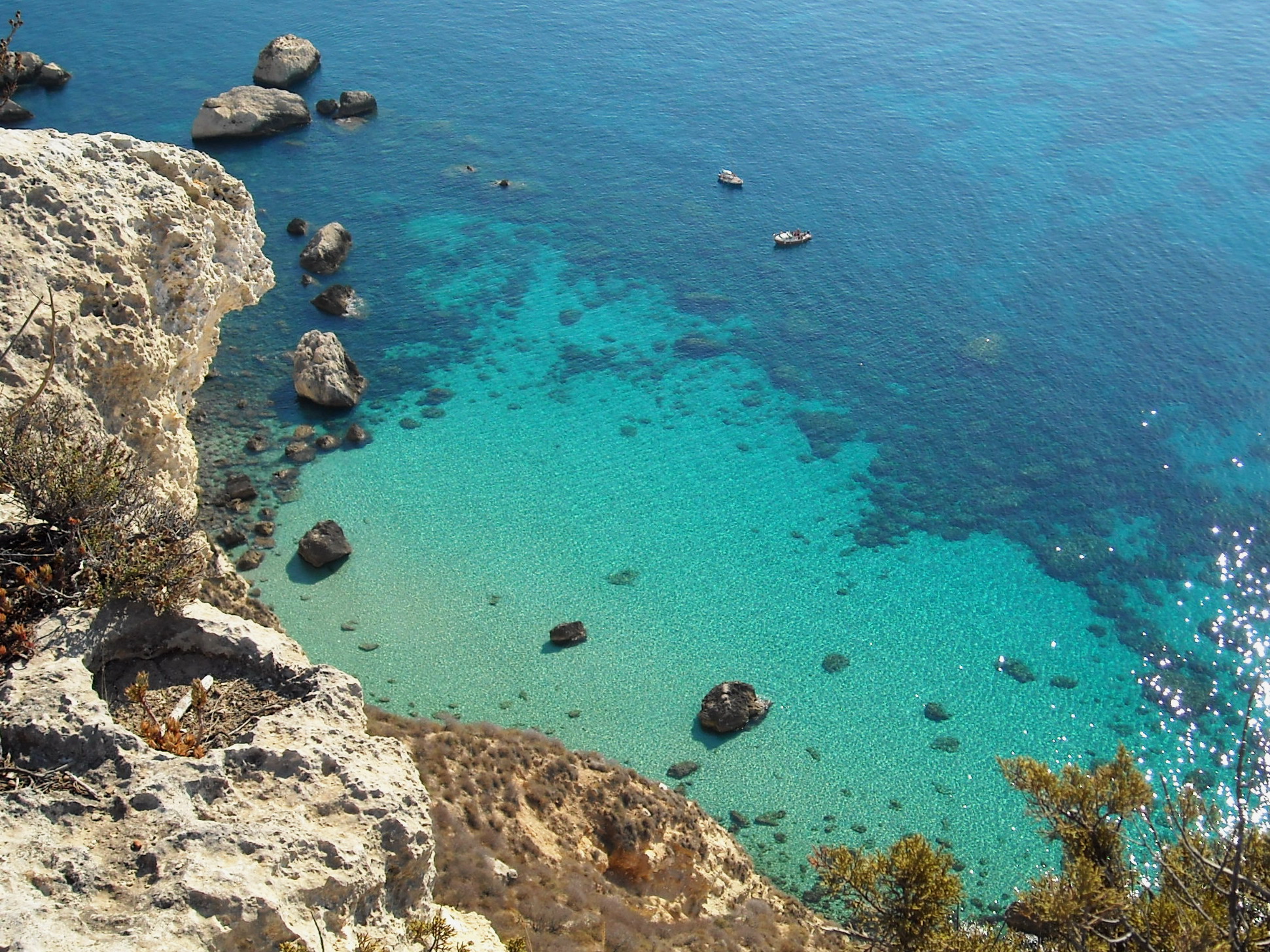 Acqua turchese e costa rocciosa ai piedi della Sella del Diavolo